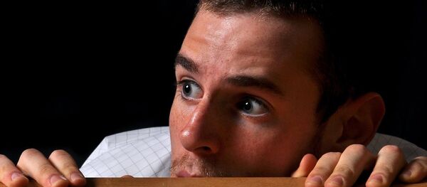 A man hiding behind a desk - Sputnik International