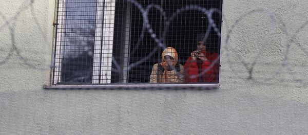 Migrants look out of a window at the Bela-Jezova refugee facility in Bela pod Bezdezem, Czech Republic, Thursday, Nov. 5, 2015 - Sputnik International