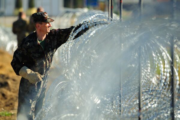 Slovenian soldiers build a razor wire fence on the Slovenian-Croatian border in Gibina, northeastern Slovenia, on November 11, 2015. - Sputnik International