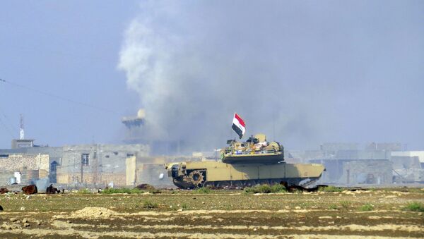 A national flag waves on an Iraqi Army Abrams tank as Iraqi forces supported by U.S.-led coalition airstrikes advance their position during clashes with Islamic State group in the western suburbs of Ramadi, the capital of Iraq's Anbar province, 70 miles (115 kilometers) west of Baghdad, Iraq, Saturday, Nov. 21, 2015 - Sputnik International