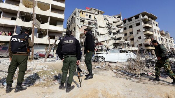 A general view shows Syrian police standing guard at the site of a reported Israeli air raid that killed a senior figure in the Lebanese Shiite militant group Hezbollah, Samir Kantar, in Jaramana, southeast of the Syrian capital Damascus - Sputnik International