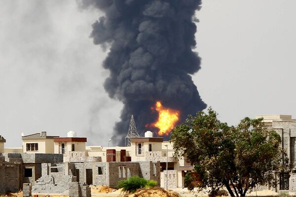 A picture taken on July 28, 2014 shows flames and smoke billowing from an oil depot where a huge blaze started following clashes around Tripoli airport, in southern Tripoli A picture taken on July 28, 2014 shows flames and smoke billowing from an oil depot where a huge blaze started following clashes around Tripoli airport, in southern Tripoli - Sputnik International