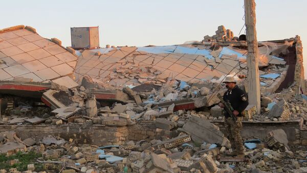 A member of the Iraqi security forces stands in the rubble of destroyed buildings in the rural Husayba al-Sharkiya area, east of Anbar province's capital Ramadi, as they undertake military operations to attack Islamic State (IS) group positions on December 20, 2015. - Sputnik International