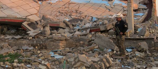 A member of the Iraqi security forces stands in the rubble of destroyed buildings in the rural Husayba al-Sharkiya area, east of Anbar province's capital Ramadi, as they undertake military operations to attack Islamic State (IS) group positions on December 20, 2015. A member of the Iraqi security forces stands in the rubble of destroyed buildings in the rural Husayba al-Sharkiya area, east of Anbar province's capital Ramadi, as they undertake military operations to attack Islamic State (IS) group positions on December 20, 2015. - Sputnik International