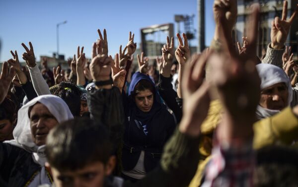 Members of the Kurdish community flash the V for victiry sign during a demonstration in Sirnak - Sputnik International