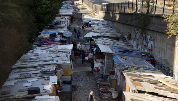 People walk between makeshift shelters of the Roma camp at the boulevard Ney in Paris - Sputnik International
