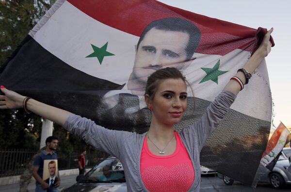 A Syrian girl holds her national flag bearing a portrait of Syria's President Bashar al-Assad A Syrian girl holds her national flag bearing a portrait of Syria's President Bashar al-Assad - Sputnik International