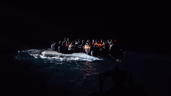 Syrian migrants aboard an inflatable dinghy are about to be rescued while attempting to reach the Greek Island Chios, on the Agean Sea near Izmir in the night of December 9 to December 10, 2015 - Sputnik International