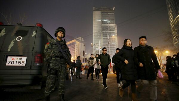 An armed policeman from the Snow Leopard Commando Unit stands guard next to a police van at the Sanlitun area, a fashionable location for shopping and dining, on Christmas Eve in Beijing, China, December 24, 2015. - Sputnik International