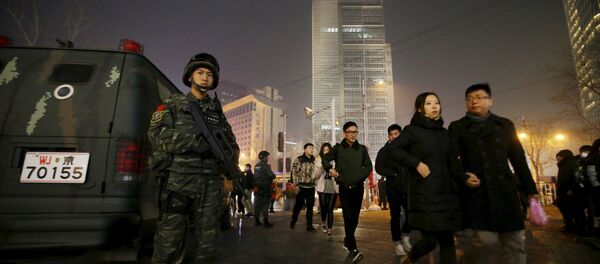 An armed policeman from the Snow Leopard Commando Unit stands guard next to a police van at the Sanlitun area, a fashionable location for shopping and dining, on Christmas Eve in Beijing, China, December 24, 2015. An armed policeman from the Snow Leopard Commando Unit stands guard next to a police van at the Sanlitun area, a fashionable location for shopping and dining, on Christmas Eve in Beijing, China, December 24, 2015. - Sputnik International
