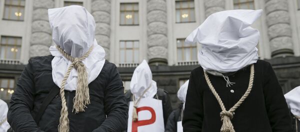 Activists with bags on their heads and ropes around their necks demand an increase in state funding for the treatment of seriously ill people in front of the government building in Kiev, Ukraine, December 23, 2015 - Sputnik International