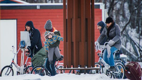 Refugees walk alongside there bikes to the Norwegian border crossing station at Storskog after crossing the border from Russia on November 12, 2015 near Kirkenes - Sputnik International
