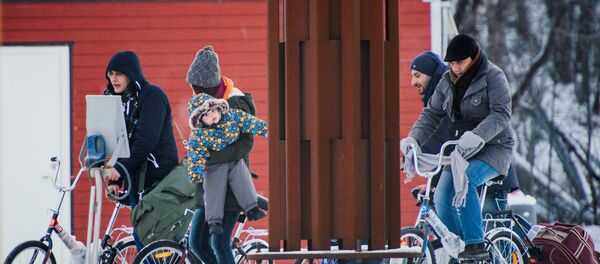 Refugees walk alongside there bikes to the Norwegian border crossing station at Storskog after crossing the border from Russia on November 12, 2015 near Kirkenes Refugees walk alongside there bikes to the Norwegian border crossing station at Storskog after crossing the border from Russia on November 12, 2015 near Kirkenes - Sputnik International