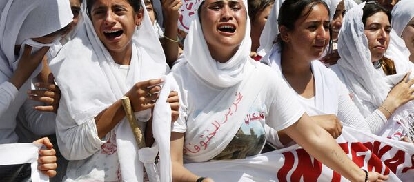 Yazidi Kurdish women chant slogans during a protest against the Islamic State group's invasion on Sinjar city one year ago, in Dohuk, northern Iraq, Monday, Aug. 3, 2015 - Sputnik International