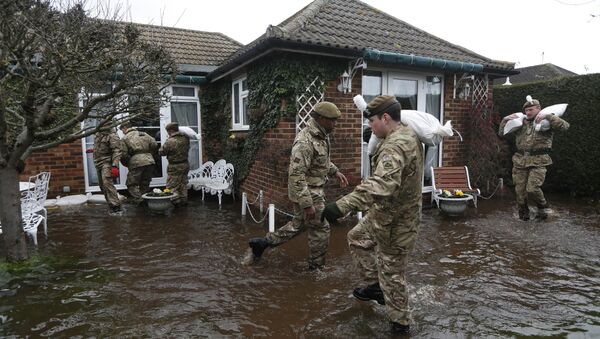 British army soldiers place sandbags at the entrance to a flooded house at Chertsey, England, Wednesday, Feb. 12, 2014 - Sputnik International