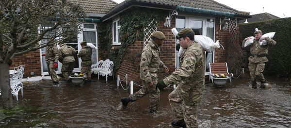 British army soldiers place sandbags at the entrance to a flooded house at Chertsey, England, Wednesday, Feb. 12, 2014 British army soldiers place sandbags at the entrance to a flooded house at Chertsey, England, Wednesday, Feb. 12, 2014 - Sputnik International