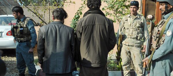 Afghan security forces stand guard around two arrested so-called IS fighters in Jalalabad, capital of Nangarhar province, Afghanistan, Wednesday, Dec. 23, 2015 - Sputnik International