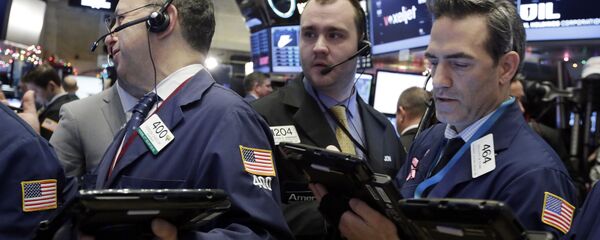 FILE - In this Dec. 16, 2015 file photo, traders Gordon Charlop, left, Nathan Wisniewski, center, and Gregory Rowe, work on the floor of the New York Stock Exchange. Stocks were mostly flat in early trading Tuesday, Dec. 22, 2015, helped by a stabilization in oil prices, which helped lift energy stocks - Sputnik International
