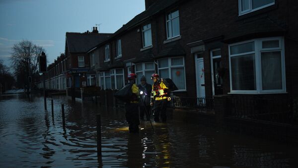 Members of the RSPCA help a woman retrieve possessions from her flooded property in Carlisle, north west England on December 7, 2015 - Sputnik International