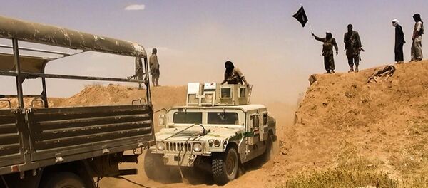 Islamic State of Iraq and the Levant (ISIL) militants waving the trademark Jihadits flag as vehicles drive on a newly cut road through the Syrian-Iraqi border between the Iraqi Nineveh province and the Syrian town of Al-Hasakah (File) - Sputnik International