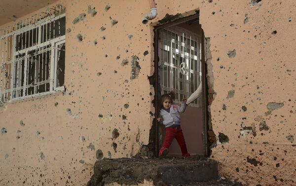 A girl stands at the entrance of a damaged house in the Sur district in Diyarbakir on December 11, 2015. - Sputnik International