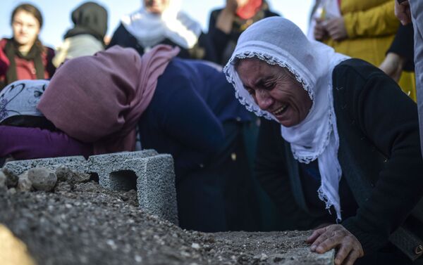 A relative grieves at the grave of Medeni Orak, killed  in the southeastern city of Nusaybin, on December 24, 2015, in Mardin province. - Sputnik International