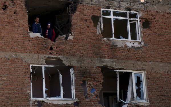 People look out from a building which was damaged during the security operations and clashes between Turkish security forces and Kurdish militants, in Sur district of Diyarbakir, Turkey, December 11, 2015. - Sputnik International