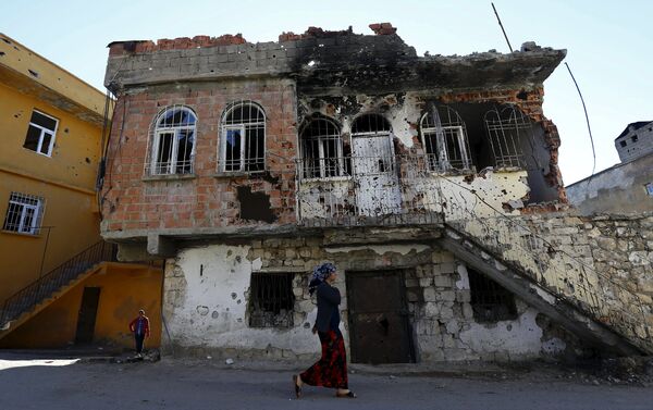 A woman walks past a building which was damaged during the security operations and clashes between Turkish security forces and Kurdish militants, in the southeastern town of Silvan in Diyarbakir province, Turkey, December 7, 2015. - Sputnik International
