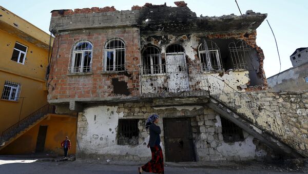 File Photo: A woman walks past a building which was damaged during the security operations and clashes between Turkish security forces and Kurdish militants, in the southeastern town of Silvan in Diyarbakir province, Turkey, December 7, 2015. - Sputnik International