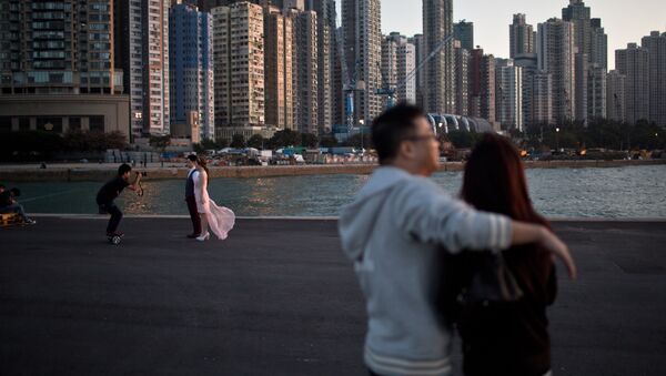 A couple (L) pose for their pre-wedding photographs on a public pier in Hong Kong on November 28, 2015 - Sputnik International