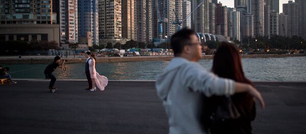 A couple (L) pose for their pre-wedding photographs on a public pier in Hong Kong on November 28, 2015 - Sputnik International