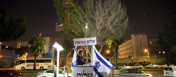 An Israeli activist hands out signs prior to a protest against an investigation into the funding of a number of left-wing NGO's in Israel - Sputnik International