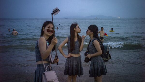 Chinese women pose for a picture on the beach in Qingdao, eastern China's Shandong province on July 24, 2015 - Sputnik International