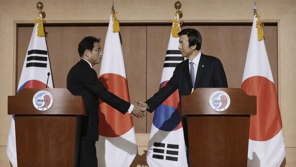South Korean Foreign Minister Yun Byung-se, right, shakes hands with his Japanese counterpart Fumio Kishida after their joint press conference at Foreign Ministry in Seoul, South Korea, Monday, Dec. 28, 2015. The foreign ministers said they had reached a deal meant to resolve a decades-long impasse over Korean women forced into Japanese military-run brothels during World War II, a potentially dramatic breakthrough between the Northeast Asian neighbors and rivals - Sputnik International