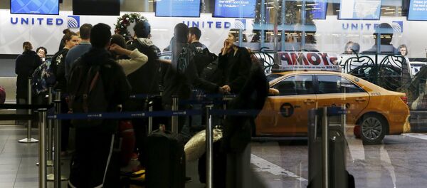 Air travelers are seen reflected through a window while waiting to check in for flights at LaGuardia Airport in New York Air travelers are seen reflected through a window while waiting to check in for flights at LaGuardia Airport in New York - Sputnik International