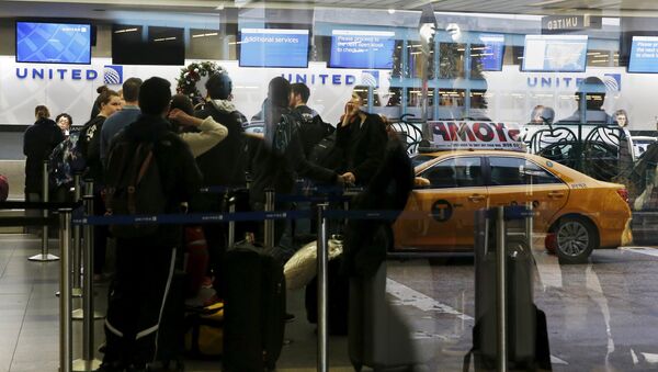 Air travelers are seen reflected through a window while waiting to check in for flights at LaGuardia Airport in New York - Sputnik International