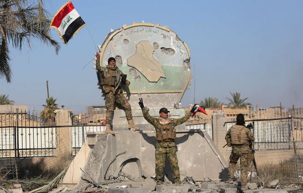 A member of the Iraqi security forces holds an Iraqi flag at a government complex in the city of Ramadi, December 28, 2015 A member of the Iraqi security forces holds an Iraqi flag at a government complex in the city of Ramadi, December 28, 2015 - Sputnik International
