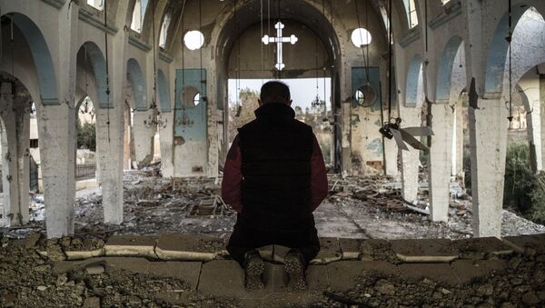 File Photo: A resident of a village in the province of al-Hasake in the north-east of Syria prays in St. George's Church destroyed by Daesh terrorists. - Sputnik International