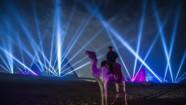 An Egyptian policeman riding a camel stands guard during New Year celebrations in front of the pyramids near the Egyptian capital Cairo on January 1, 2016 - Sputnik International