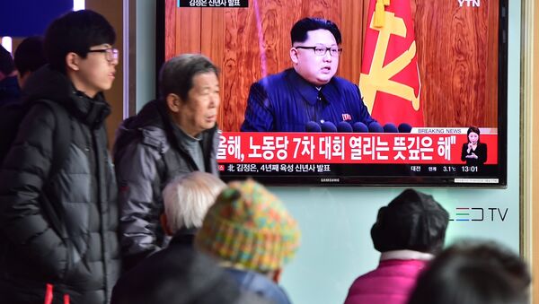 Commuters walk past a television screen showing a broadcast of North Korean leader Kim Jong-Un's New Year speech, at a railroad station in Seoul on January 1, 2016 - Sputnik International
