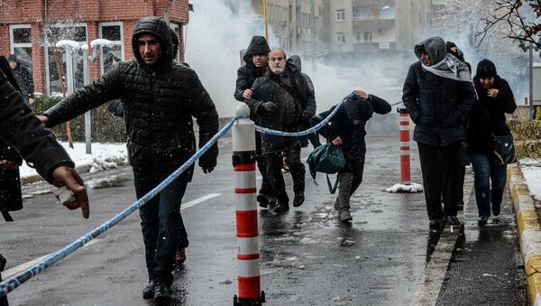Peoples' Democratic Party (HDP) MP Ertugrul Kurkcu (back L 2nd) and protesters run away as Turkish police officers use tear gas to disperse the crowd on December 31, 2015 in Diyarbakir, during a demonstration after a curfew was partially lifted from the city on December 30 - Sputnik International