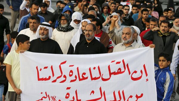 Protesters holding a banner saying Death is normal to us and our dignity from God is martyrdom take part in a protest against the execution of Saudi Shi'ite cleric Nimr al-Nimr by Saudi authorities, in the village of Sanabis, west of Manama, Bahrain January 2, 2016 - Sputnik International
