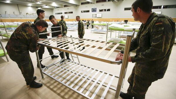 Soldiers from the guards battalion of the German armed forces Bundeswehr prepare beds as they transform the sports hall of the Jane-Addams high school into a refugee shelter in Hohenschoenhausen district in Berlin, Germany, December 8, 2015 - Sputnik International
