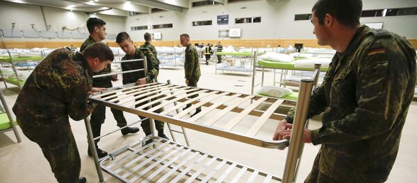 Soldiers from the guards battalion of the German armed forces Bundeswehr prepare beds as they transform the sports hall of the Jane-Addams high school into a refugee shelter in Hohenschoenhausen district in Berlin, Germany, December 8, 2015 - Sputnik International