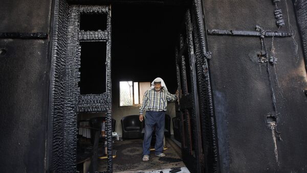 FILE - In this July 31, 2015 file photo, a Palestinian inspects a house after it was torched in a suspected attack by Jewish settlers, killing an 18-month-old Palestinian child and his parents, at Duma village near the West Bank city of Nablus - Sputnik International