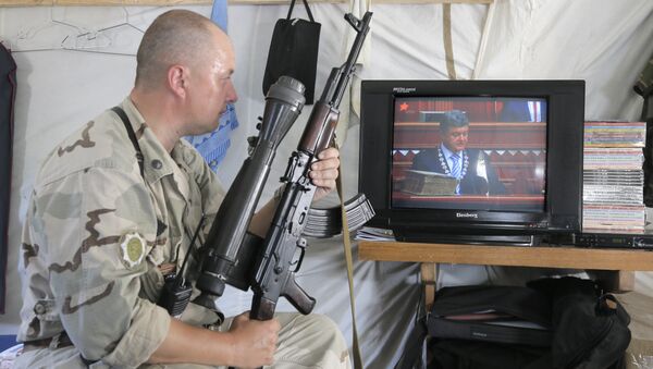 Ukrainian soldier watches the inauguration ceremony of Ukrainian President-elect Petro Poroshenko on TV in a tent at the Ukraine's Army position close to Slovyansk, Ukraine, Saturday, June 7, 2014 - Sputnik International