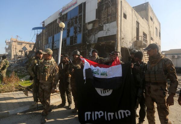Iraqi security forces place the Iraqi flag above the Islamic State group flag as they pose for a picture on December 28, 2015 in front of the Anbar police headquarters after they recaptured the city of Ramadi, the capital of Iraq's Anbar province, about 110 kilometers west of Baghdad Iraqi security forces place the Iraqi flag above the Islamic State group flag as they pose for a picture on December 28, 2015 in front of the Anbar police headquarters after they recaptured the city of Ramadi, the capital of Iraq's Anbar province, about 110 kilometers west of Baghdad - Sputnik International