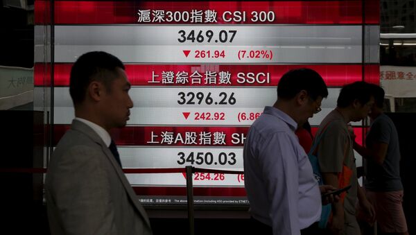 People walk past a panel displaying Chinese stock market indexes in Hong Kong, China January 4, 2016 - Sputnik International
