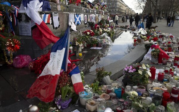 People stand next to the makeshift memorial in tribute to the victims of the Paris terror attacks, on January 4, 2016, at the Place de la Republique in Paris. - Sputnik International