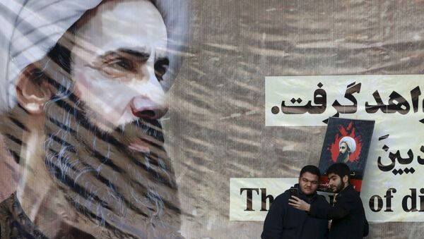 Iranian men take a selfie with a poster of Sheikh Nimr al-Nimr, a prominent opposition Saudi Shiite cleric, who was executed last week by Saudi Arabia. - Sputnik International